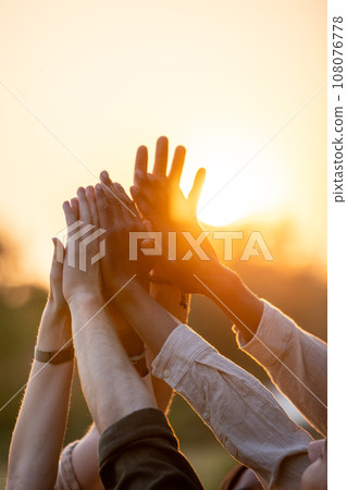 Diverse Group High-Fiving at Sunset Diverse Group High-Fiving at Sunset 108076778