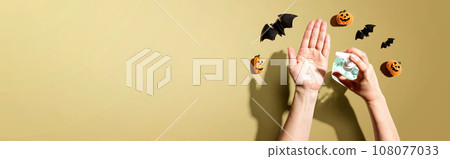 Applying sanitizer gel with Halloween theme Applying sanitizer gel with Halloween theme 108077033