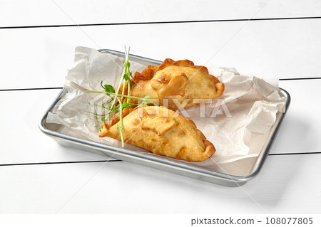 Savory puff pastry turnovers filled with salmon, spinach, cream cheese and herbs 108077805