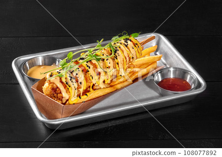 Corn dog in cornmeal batter with potato fries, sweet chili and cheddar sauces 108077892