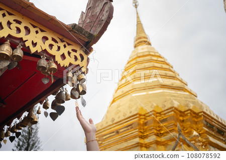 woman hand touch to small bell in temple at chiangmai Thailand in summer season woman hand touch to small bell in temple at chiangmai Thailand in summer season 108078592