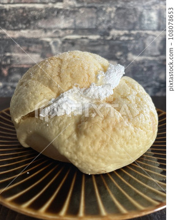 Melon bread with whipped cream filling - a luxurious bakery treat. Melon bread with whipped cream filling - a luxurious bakery treat. 108078653