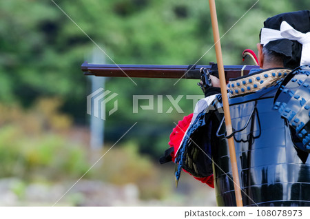 A man holding a matchlock gun A man holding a matchlock gun 108078973