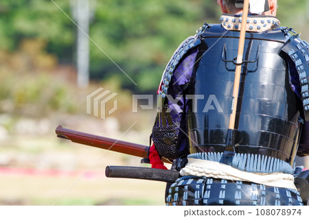 A man holding a matchlock gun 108078974