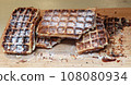 A lot of Freshly made belgian waffles sprinkled powdered sugar 108080934