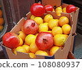 Oranges and pomegranates in a cardboard box at a street market 108080937