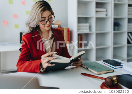 Portrait of a Asian woman lawyer studying lawsuit a for a client using computer laptop , documents to video conference before going to court Portrait of a Asian woman lawyer studying lawsuit a for a client using computer laptop , documents to video conference before going to court 108082350