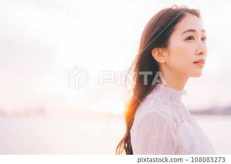 夕陽背景下的美女形象 108083273