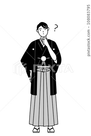 A man wearing a crested hakama tilts his head in question 108083795