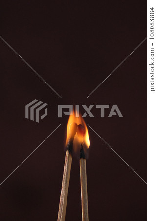 two lighted matches on a dark background 108083884