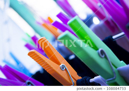 Clothespins holding clothes on clothesline. Various colors. Clothespins holding clothes on clothesline. Various colors. 108084733