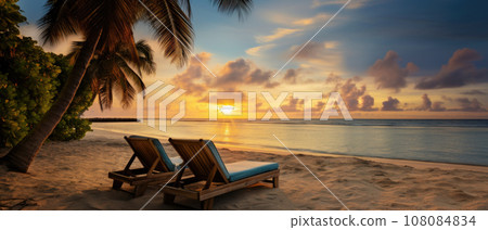 Sunset at the beach with palm trees, parasols and sunbeds. Sunset at the beach with palm trees, parasols and sunbeds. 108084834