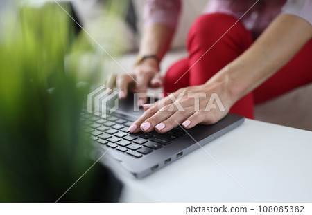 There is laptop on table. Female hands are typing text. 108085382