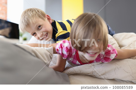 Boy and a girl on the couch are playing and laughing. Boy and a girl on the couch are playing and laughing. 108085589