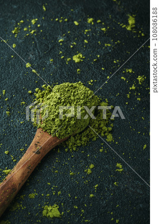 wooden spoon with some matcha powder tea 108086188