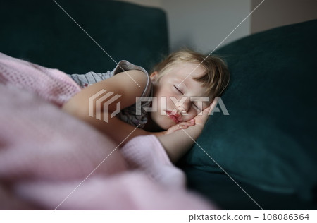 Little girl sleeps in bed with her arms folded under her head. Little girl sleeps in bed with her arms folded under her head. 108086364