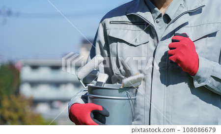 A man in work clothes holding painting tools | Image of a remodeling/painting company 108086679