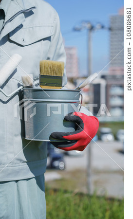 A man in work clothes holding painting tools | Image of a remodeling/painting company 108086681
