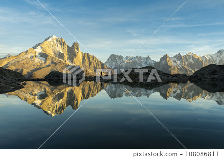 Man, Mountains and Reflection in Lac Blanc Lake at Sunset. Golden Hour. Chamonix, French Alps 108086811