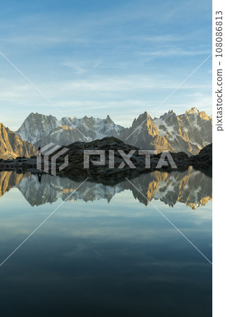Silhouette of Man, Mountains and Reflection in Lac Blanc Lake at Sunset. Golden Hour. French Alps 108086813