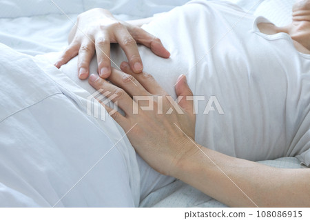 Young man uses his hands to hold his stomach and has a severe stomachache.on isolated white background 108086915
