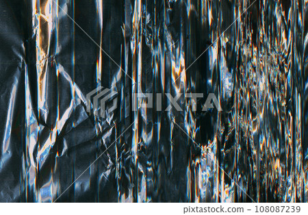 Crushed foil texture. Distressed overlay. Light flare noise. Blue orange white color glow dust scratches on glitched dark black illustration abstract background with free space. 108087239