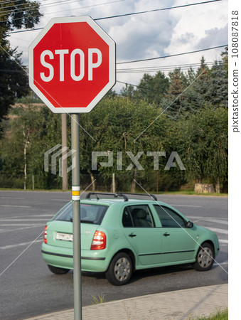 Stop sign in front of a crossing with a rides car. Stop sign in front of a crossing with a rides car. 108087818