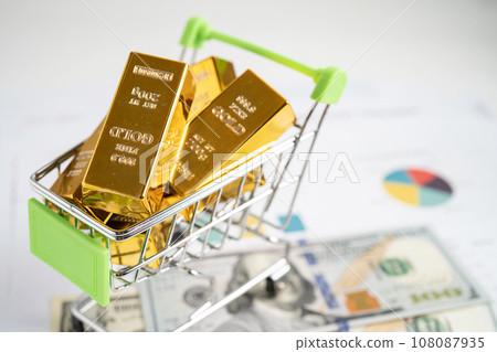 Gold bar in shopping cart on US dollar banknotes money and graph, economy finance exchange trade investment concept. 108087935