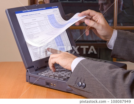 Browsing the pages on display of laptop.  Browsing the pages on display of laptop.  108087949