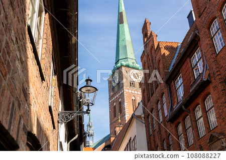 Scenic view old narrow european german Lubeck town with red brick ancient houses vintage iron stained glass lamp lantern on wall. Cityscape UNESCO heritage city altstatd in Germany travel destination Scenic view old narrow european german Lubeck town with red brick ancient houses vintage iron stained glass lamp lantern on wall. Cityscape UNESCO heritage city altstatd in Germany travel destination 108088227