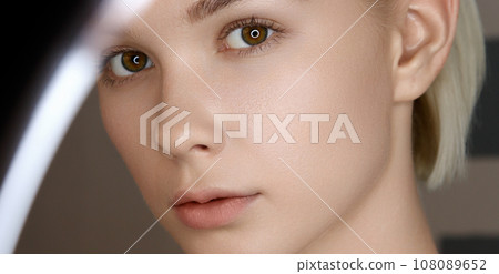 Beautiful young girl with beautiful makeup uses a 108089652