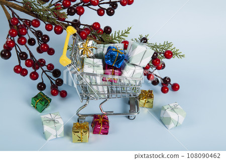 Set with a caddy filled with colorful gifts and A branch of holly with its red berries 108090462