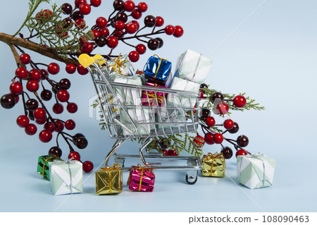 Set with a caddy filled with colorful gifts and A branch of holly with its red berries Set with a caddy filled with colorful gifts and A branch of holly with its red berries 108090463