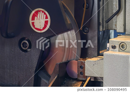 Close up scene the operation of circular blade saw cutting machine cutting the metal shaft parts with coolant method. 108090495