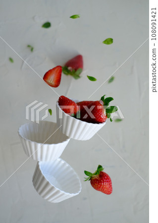Strawberries in white bowls in levitation 108091421