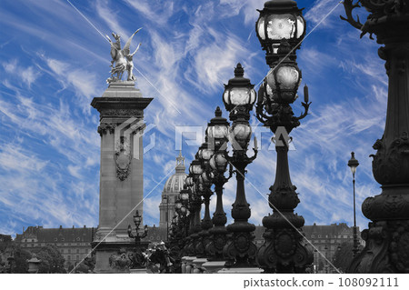 Lamp posts on Alexander III Bridge against the background of a beautiful sky with clouds. Paris, France. This arch bridge is one of the most beautiful river crossings in the world 108092111