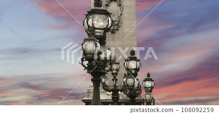Lamp posts on Alexander III Bridge against the background of a beautiful sky at sunset. Paris, France. This arch bridge is one of the most beautiful river crossings in the world Lamp posts on Alexander III Bridge against the background of a beautiful sky at sunset. Paris, France. This arch bridge is one of the most beautiful river crossings in the world 108092259