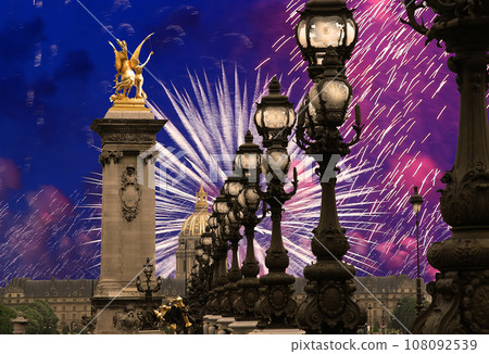 Celebratory colorful fireworks over the Lamp posts on Alexander III Bridge. Paris, France. This arch bridge is one of the most beautiful river crossings in the world Celebratory colorful fireworks over the Lamp posts on Alexander III Bridge. Paris, France. This arch bridge is one of the most beautiful river crossings in the world 108092539