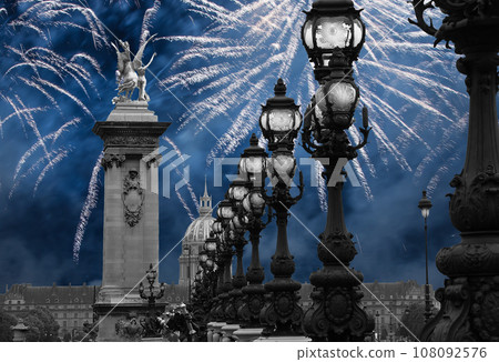 Celebratory colorful fireworks over the Lamp posts on Alexander III Bridge. Paris, France. This arch bridge is one of the most beautiful river crossings in the world Celebratory colorful fireworks over the Lamp posts on Alexander III Bridge. Paris, France. This arch bridge is one of the most beautiful river crossings in the world 108092576