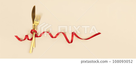 Fork and knife tied with a red ribbon. Romantic dinner. Valentine's Day 108093052