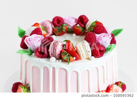 Beautiful pink cake decorated with macarons, raspberries, strawberries and sugar rose flowers. Beautiful pink cake decorated with macarons, raspberries, strawberries and sugar rose flowers. 108093362