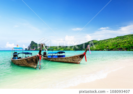 Thai traditional wooden longtail boat and beautiful sand beach at Koh Phi Phi island in Thailand. Thai traditional wooden longtail boat and beautiful sand beach at Koh Phi Phi island in Thailand. 108093407