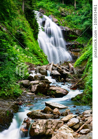 Waterfall cascade on mountain rocks. A mountain waterfall flows over the rocks. Waterfall cascade on mountain rocks. A mountain waterfall flows over the rocks. 108093461