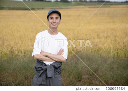 A rice farmer's arms crossed with golden rice 108093684