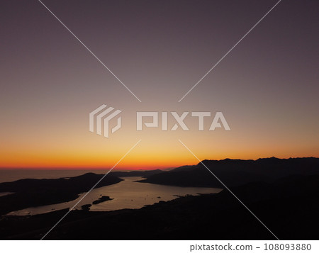 Aerial drone view of beautiful sunset or sunrise landscape with clear sky in the Bay of Kotor, Adriatic sea, Montenegro. Tranquil skyline with bright orange sunlight. Summer holiday concept 108093880