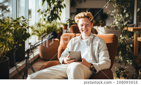 A young blogger or gamer, writes out a podcast and smiles kindly. The guy Student Streamer conducts a review 108093918