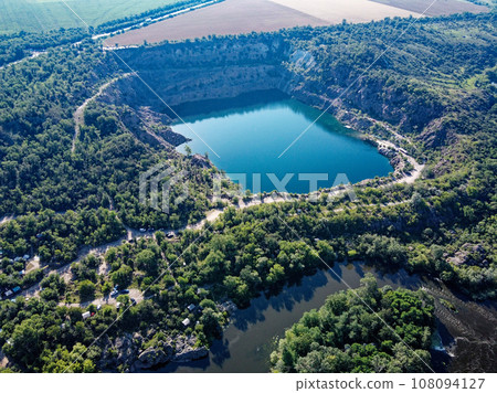 Radon lake near the Southern Bug river on a sunny summer day. Picturesque landscape from a bird's eye view. Flooded granite quarry. Radon lake near the Southern Bug river on a sunny summer day. Picturesque landscape from a bird's eye view. Flooded granite quarry. 108094127