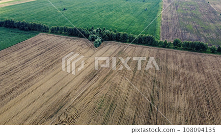 Agricultural fields, top view. Farmed fields, bird's-eye view of the landscape. Agricultural fields, top view. Farmed fields, bird's-eye view of the landscape. 108094135