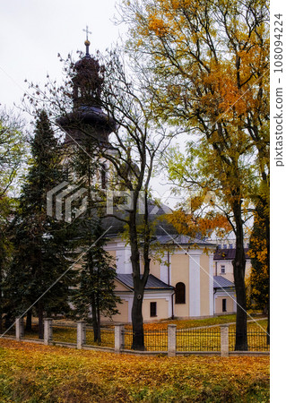 Roman Catholic Church of St. Nicholas, Zamosc. Old catholic church surrounded by autumn trees, landscape. 108094224