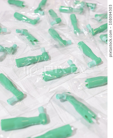 Green Disposable Prophy Angles with Brush, Ergonomic Shape on White Background. Dentistry, Orthodontic Product. Vertical Plane. Oral Hygiene. Green Disposable Prophy Angles with Brush, Ergonomic Shape on White Background. Dentistry, Orthodontic Product. Vertical Plane. Oral Hygiene. 108094303